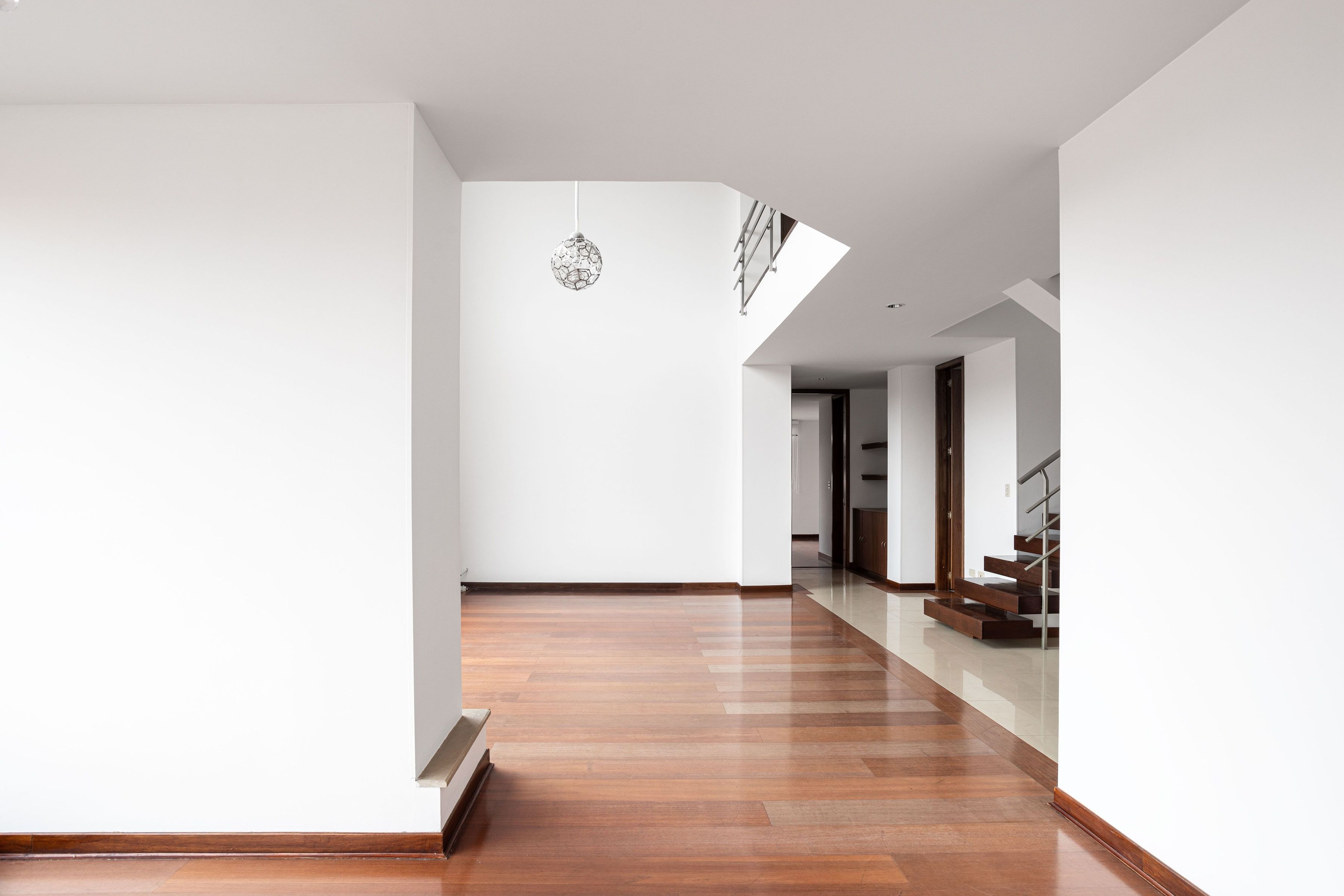 A bright interior with a glossy plank floor and wooden stairs